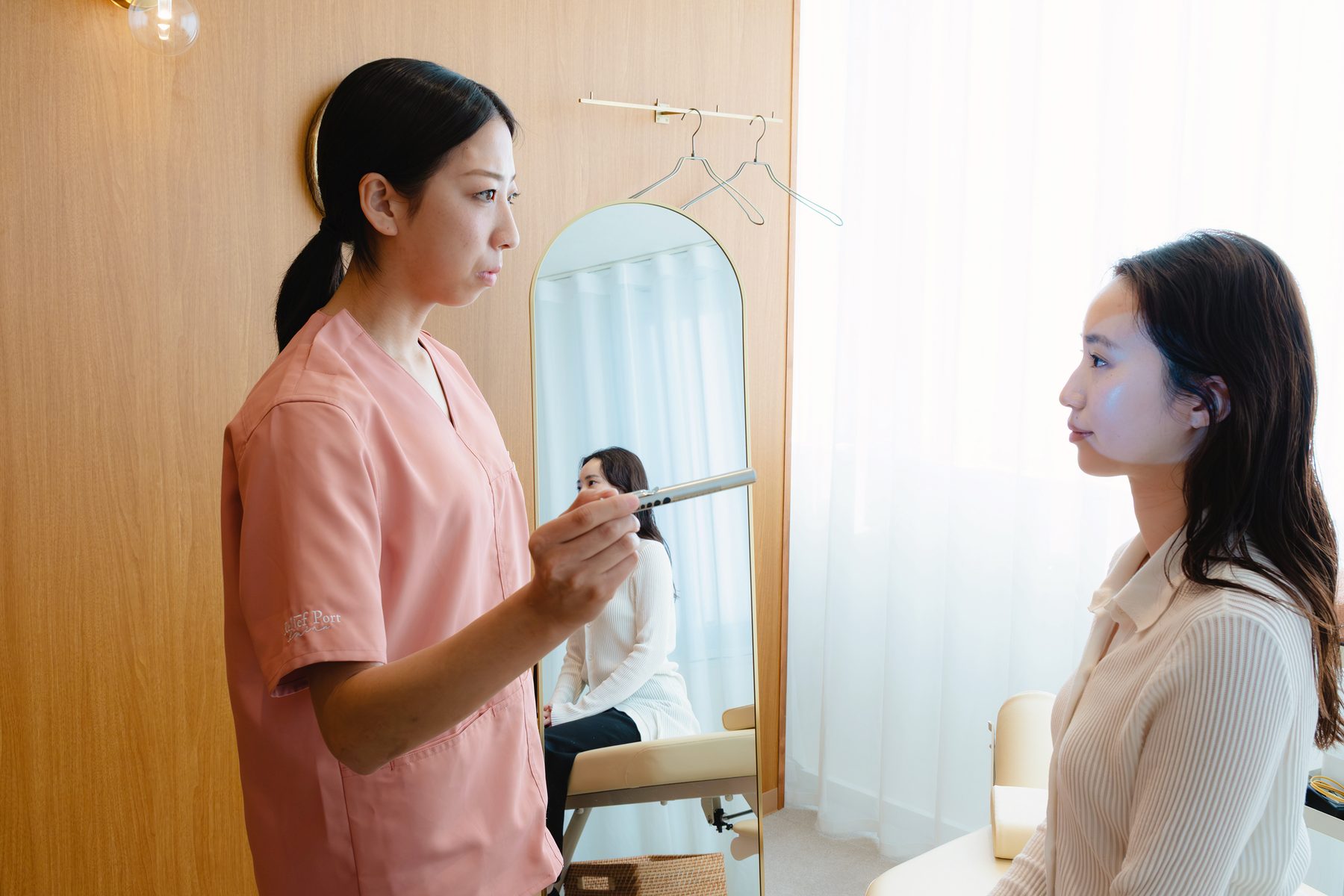 女性のセラピストがペンライトで患者様の目の反応を確かめている様子