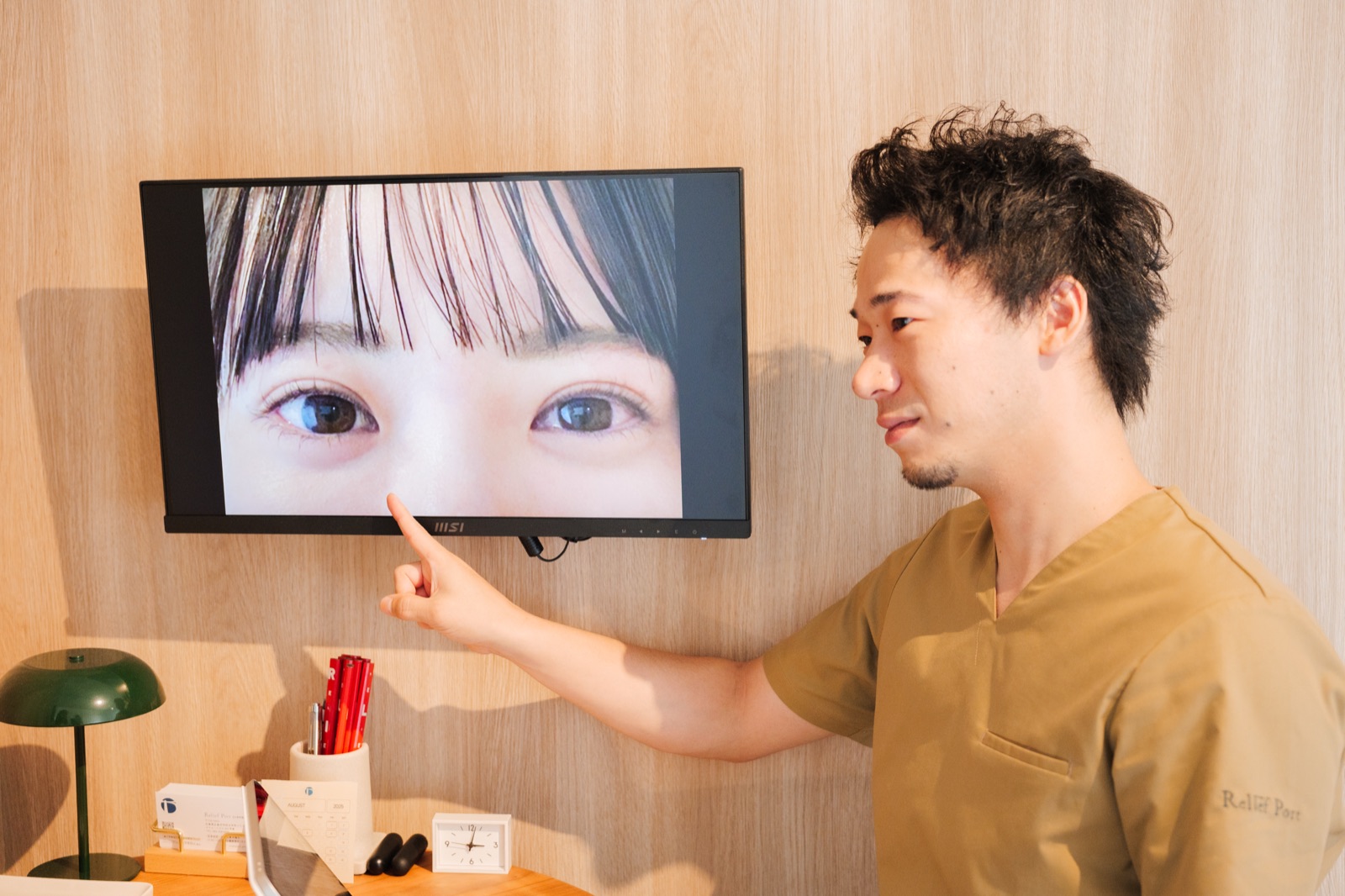 モニターに映した目の画像を指しながら説明するセラピスト